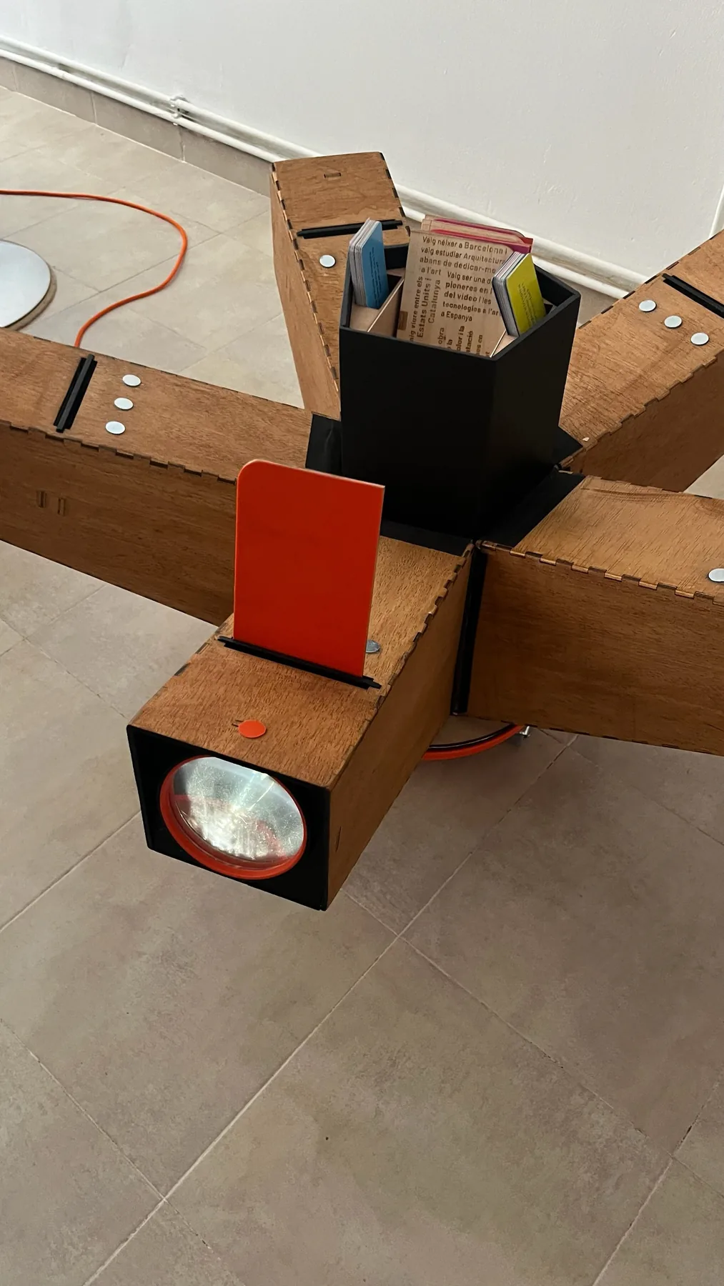Detalle de un brazo proyector de madera con una tarjeta insertada.