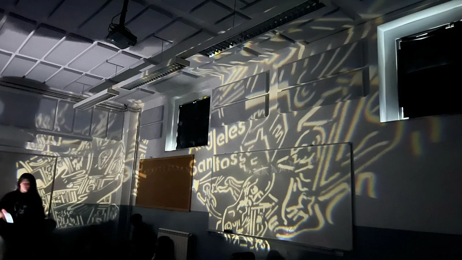 Sala cubierta por grandes proyecciones gráficas de Pioneres durante una activación.