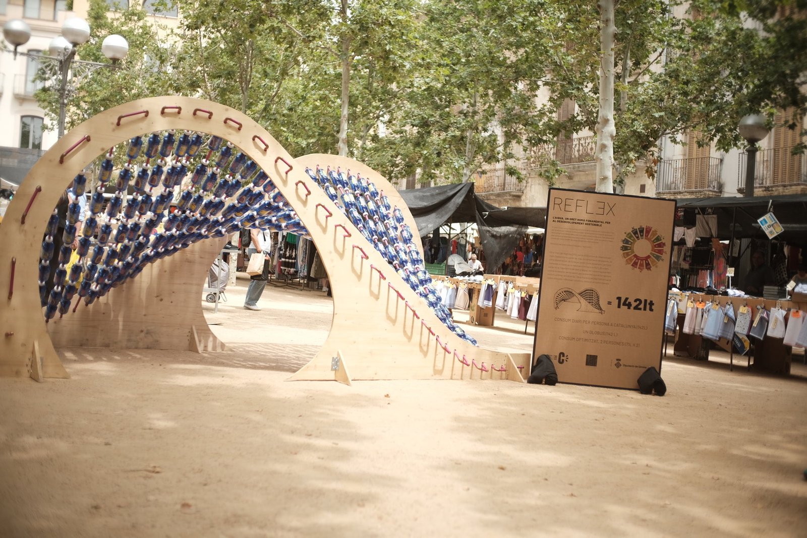 Instalación REFLEX y panel informativo en un mercado al aire libre.