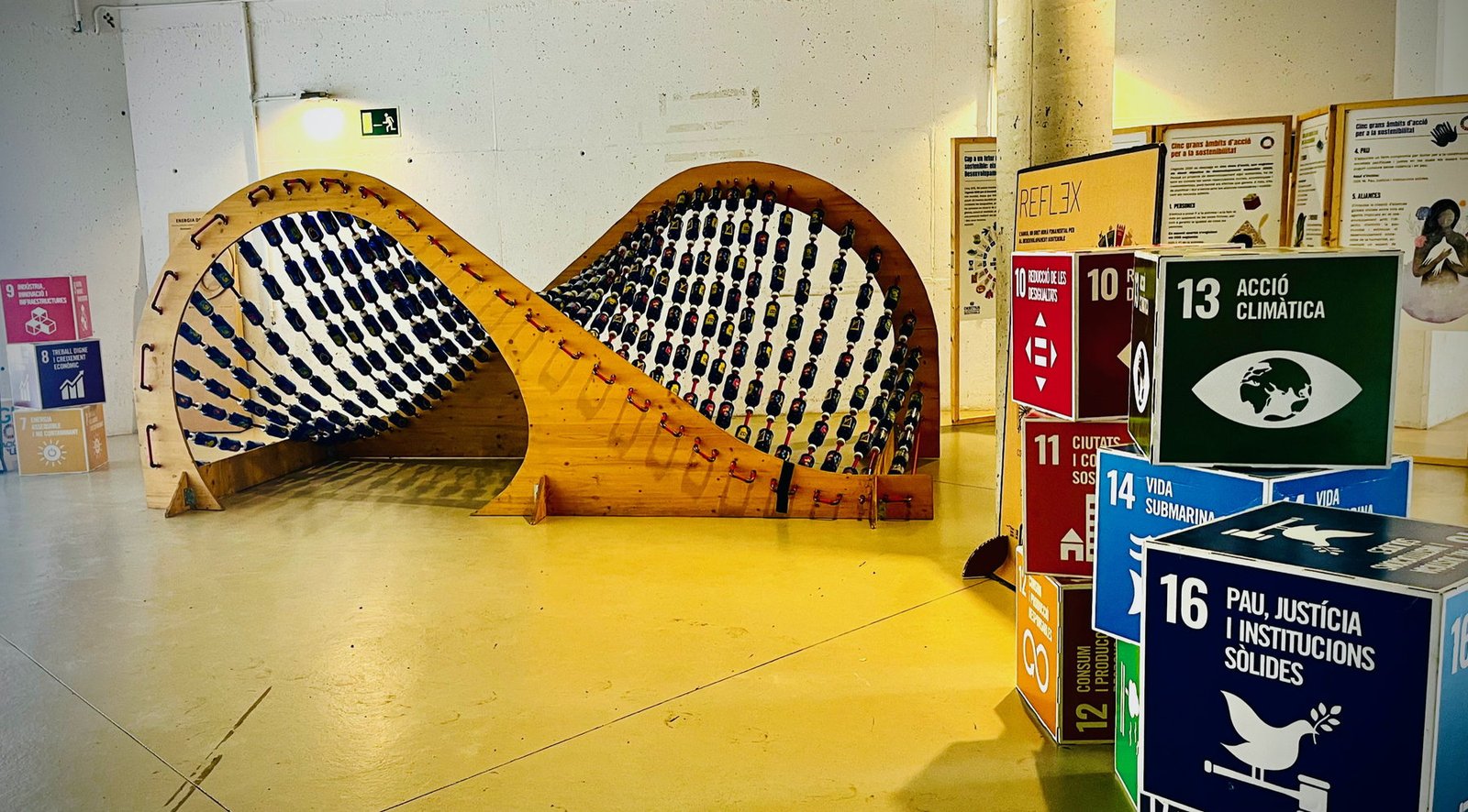 Instalación REFLEX junto a cubos informativos sobre los Objetivos de Desarrollo Sostenible.